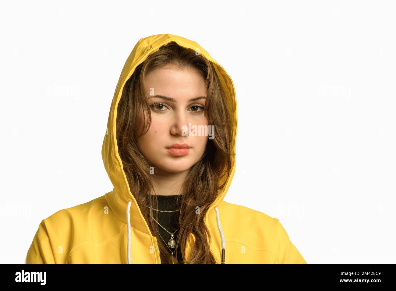 Long hair pretty young woman with noze ring. Covered head yellow raincoat with hood. isolated portrait. Stock Photo