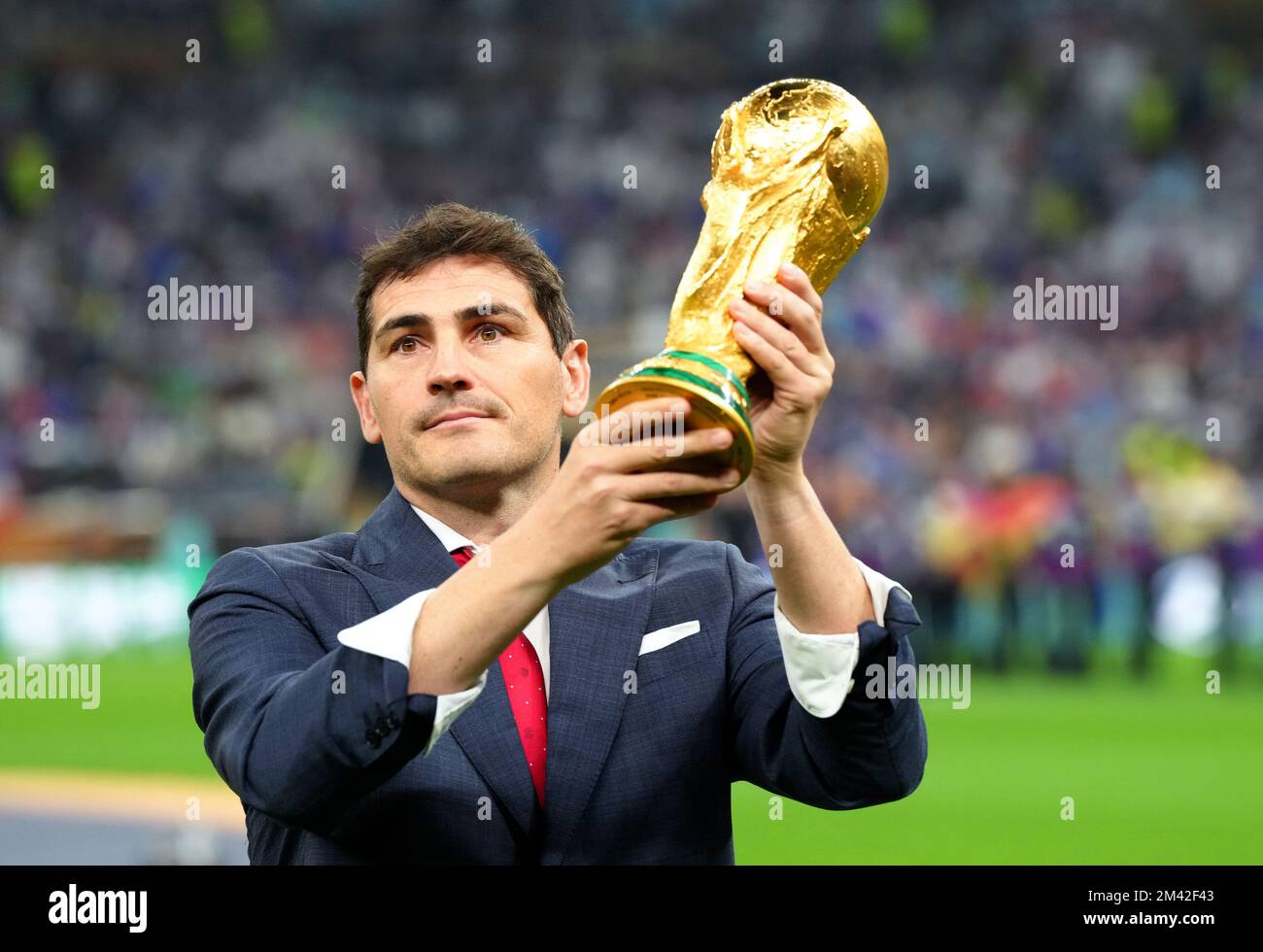 Former footballer Iker Casillas holds up the FIFA World Cup trophy