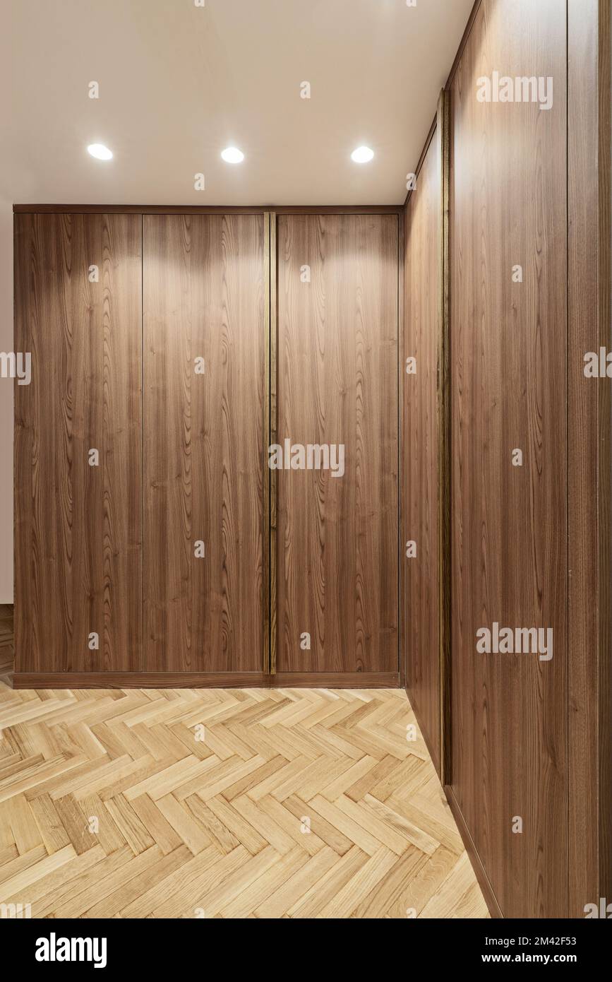 Wardrobe with root wood doors with fulllength handles in the room with