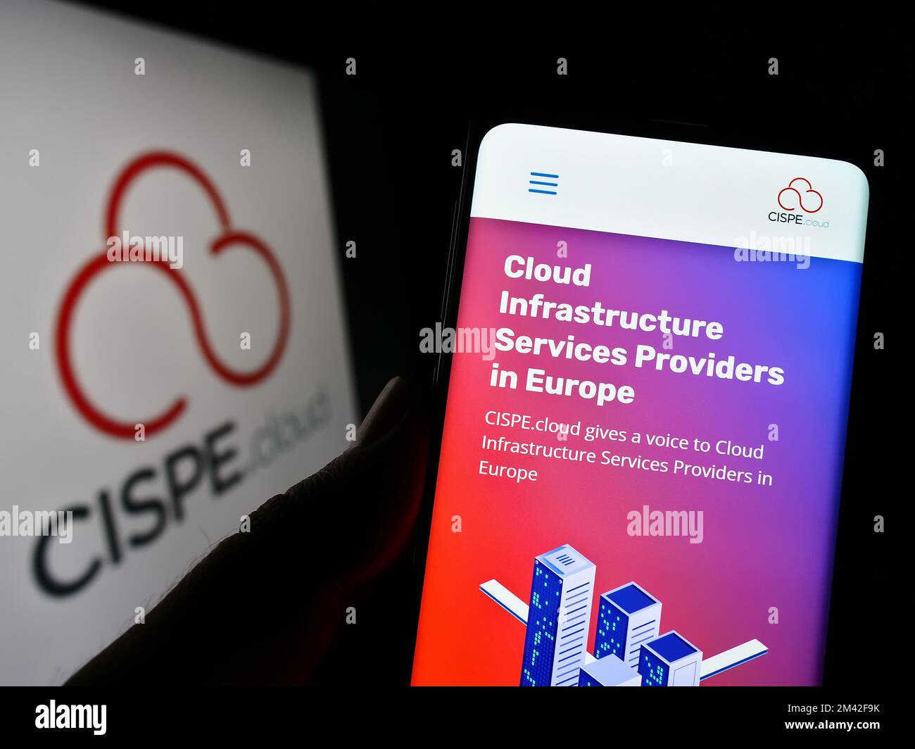 Person holding smartphone with website of cloud providers trade association CISPE on screen in front of logo. Focus on center of phone display. Stock Photo