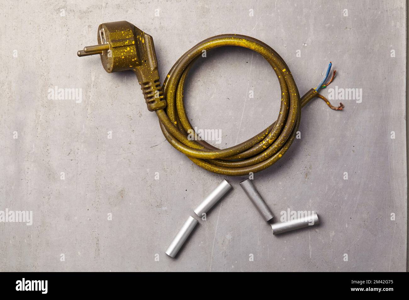 an old and broken electrical plug with its wires neatly coiled lying on