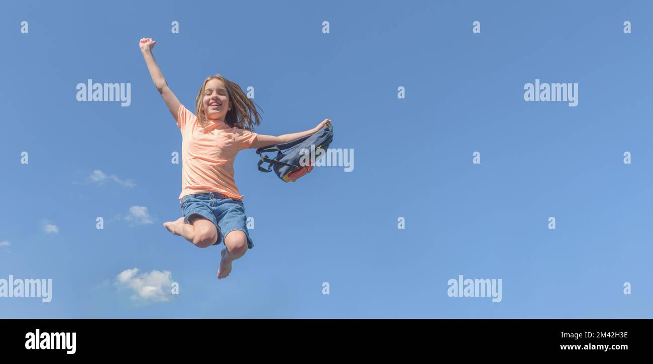 Happy summer. Girl with a school bag in a jump against the blue sky Stock Photo