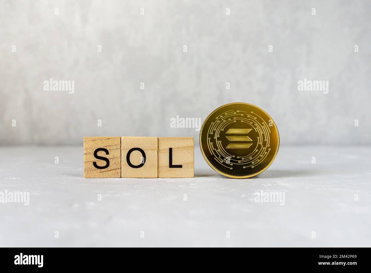 Solana single golden crypto coin with SOL text on wooden tiles. Stock Photo