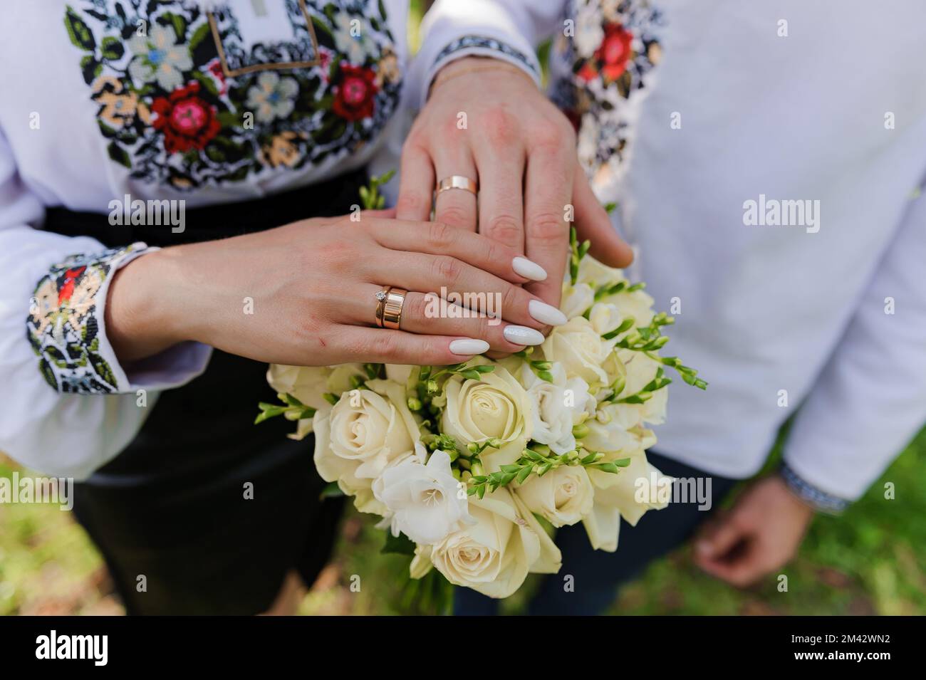 Golden wedding rings on the hands of the newlyweds. Man and woman in