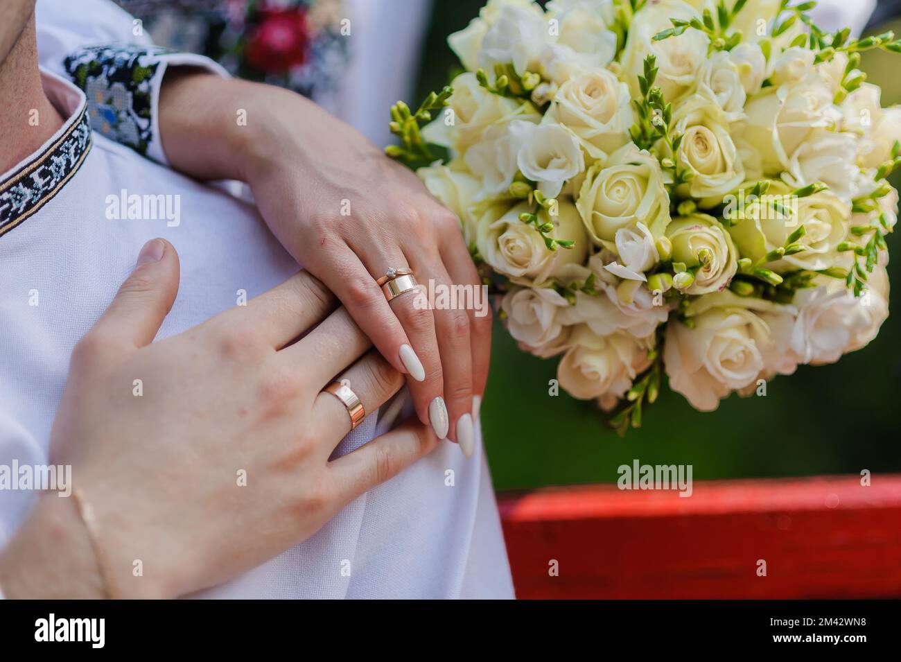 Golden wedding rings on the hands of the newlyweds. Man and woman in