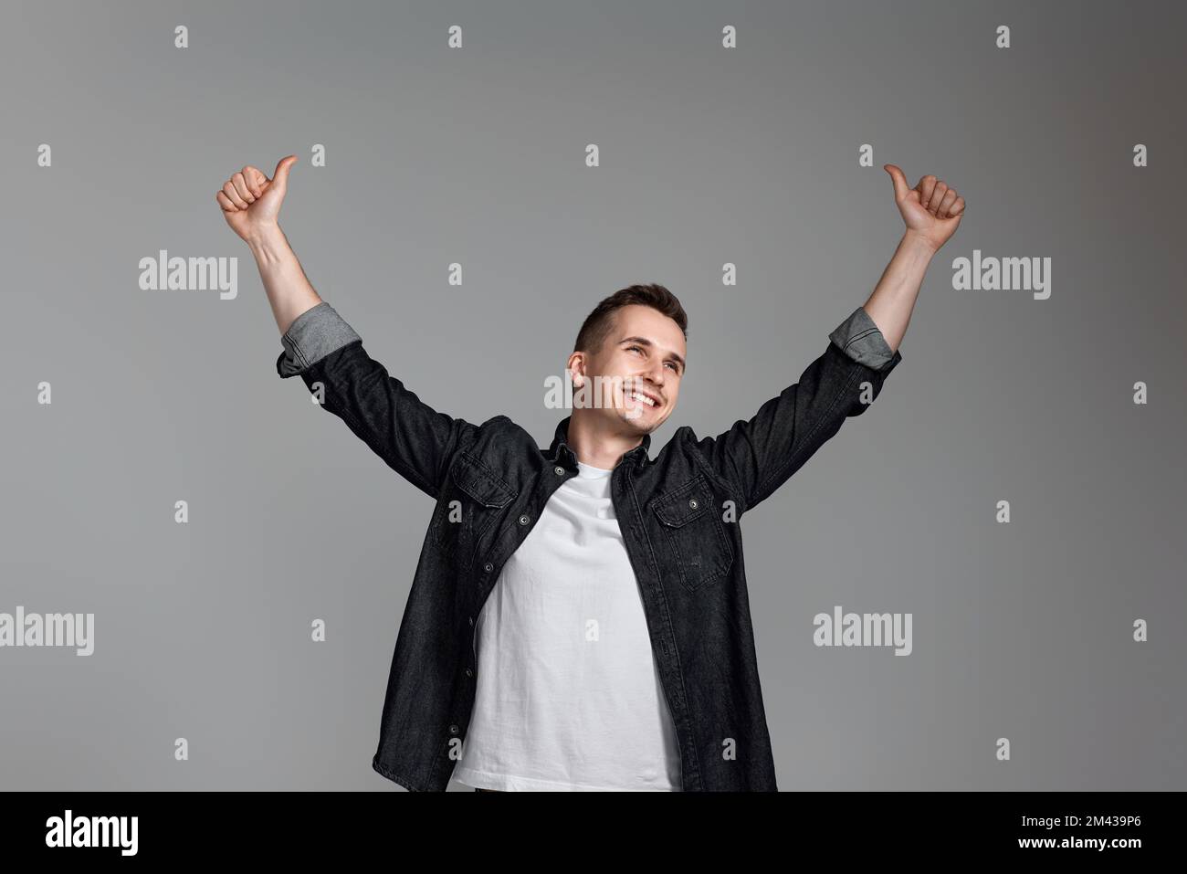amazed man celebrating victory on gray background. Stock Photo