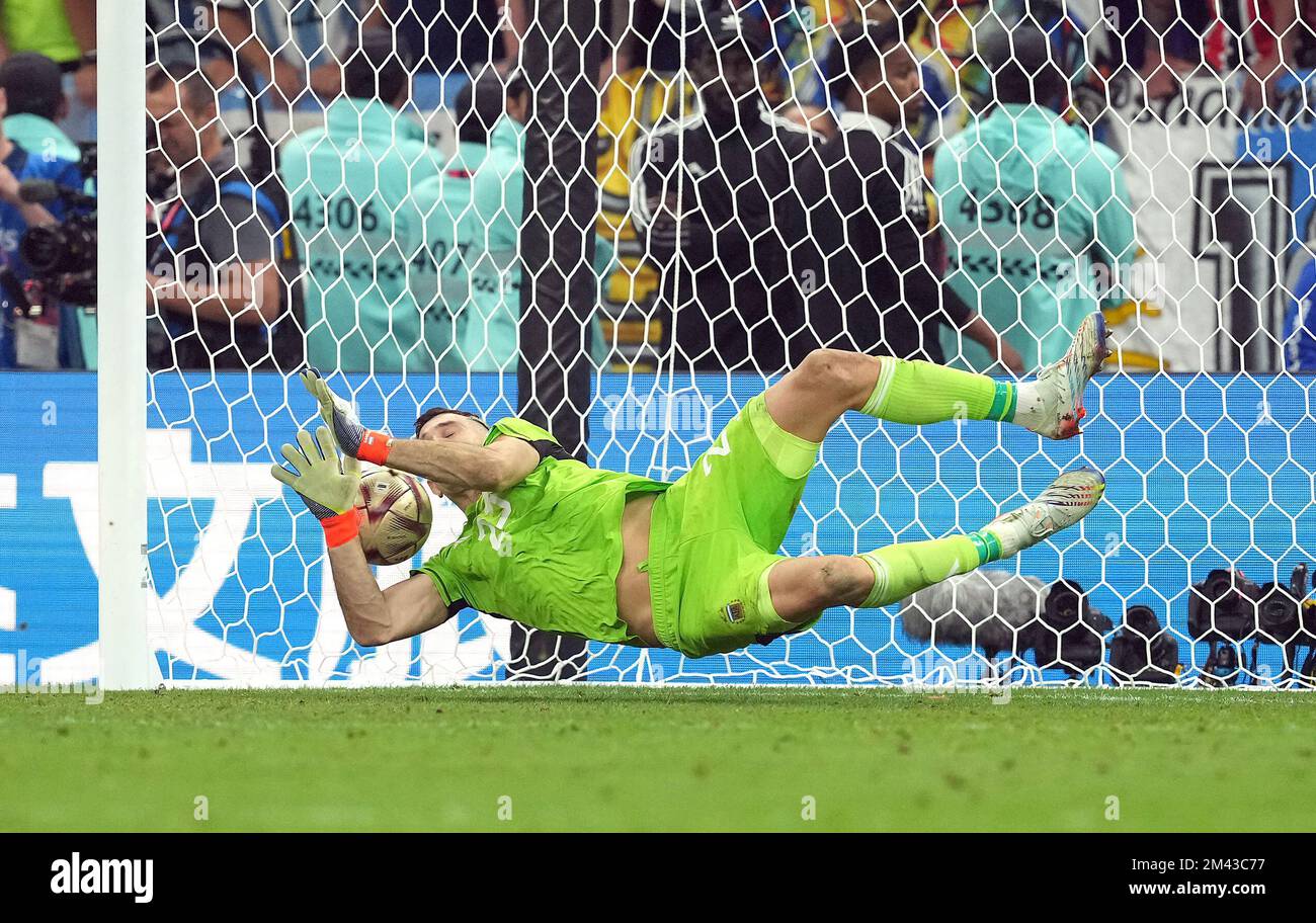Argentina goalkeeper Emiliano Martinez saves a penalty kick from France's Kingsley Coman in the penalty shoot-out after extra time during the FIFA World Cup final at Lusail Stadium, Qatar. Picture date: Sunday December 18, 2022. Stock Photo
