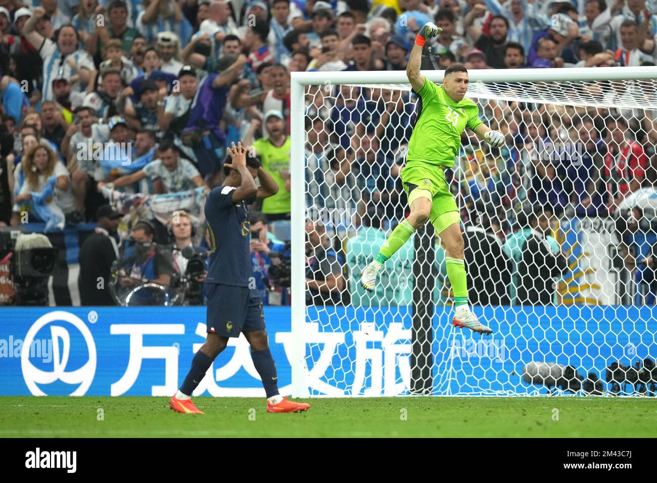 Argentina goalkeeper Emiliano Martinez (right) celebrates after saving France's Kingsley Coman's penalty in the penalty shoot-out after extra time during the FIFA World Cup final at Lusail Stadium, Qatar. Picture date: Sunday December 18, 2022. Stock Photo