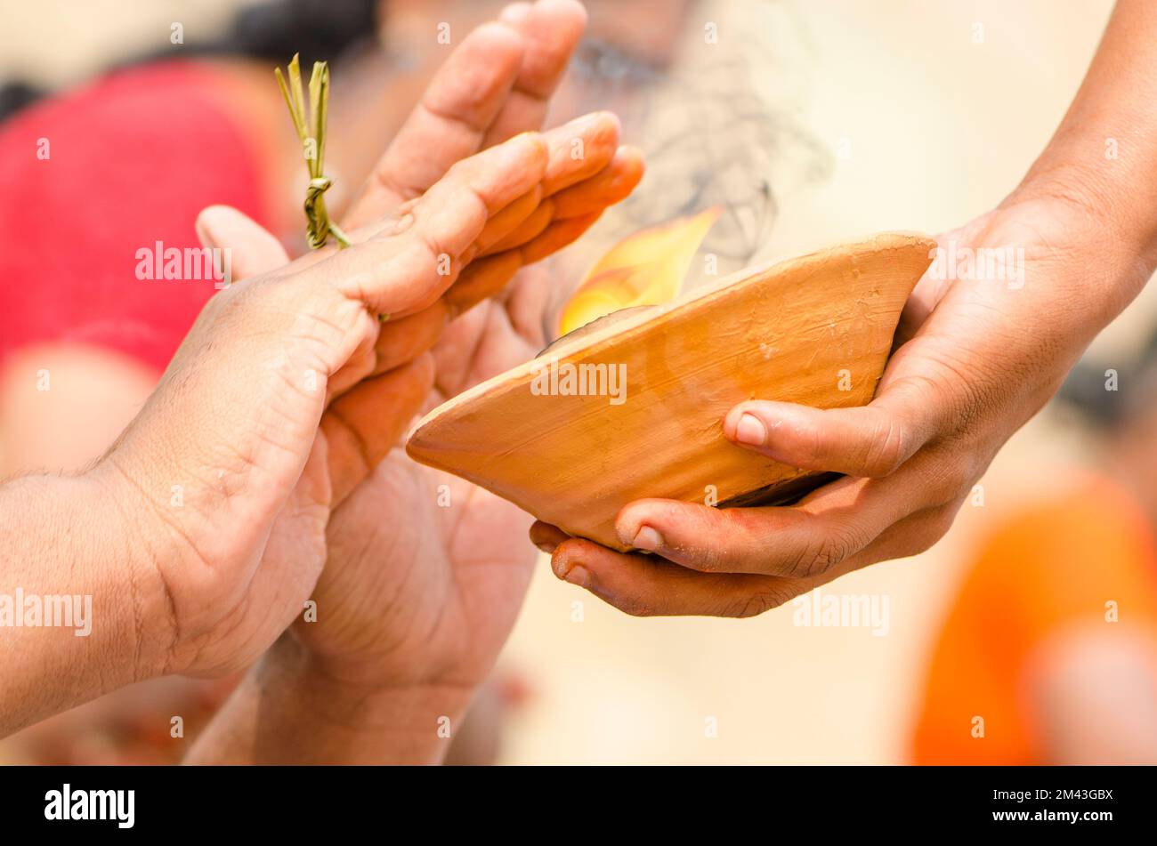 Hands over fire is part of the ritual to pray farewell for the soul of a died person, seen at the ghats Stock Photo