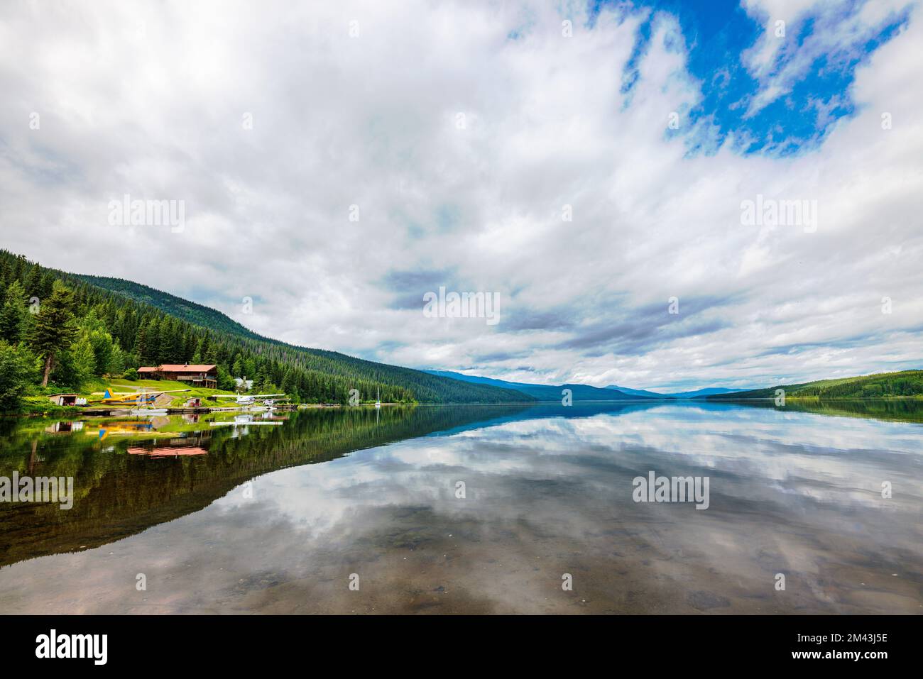 Float planes; still water reflects dramatic clouds; Dease Lake; British