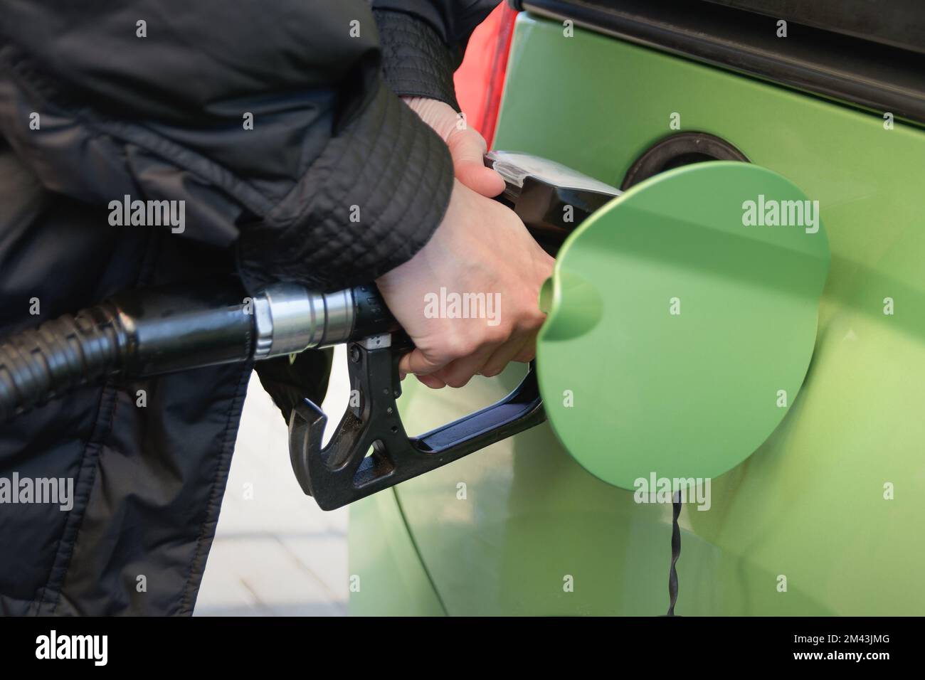 The process of filling the tank with gasoline. Refueling with gasoline at a gas station. Green car Stock Photo