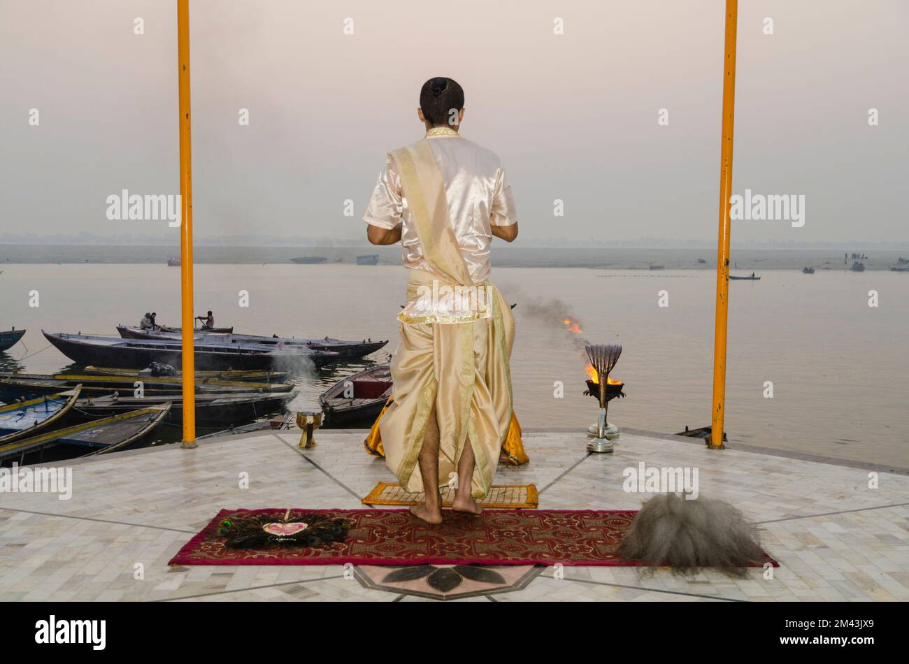 Priest performing a ceremony at sunrise at the ghats Stock Photo