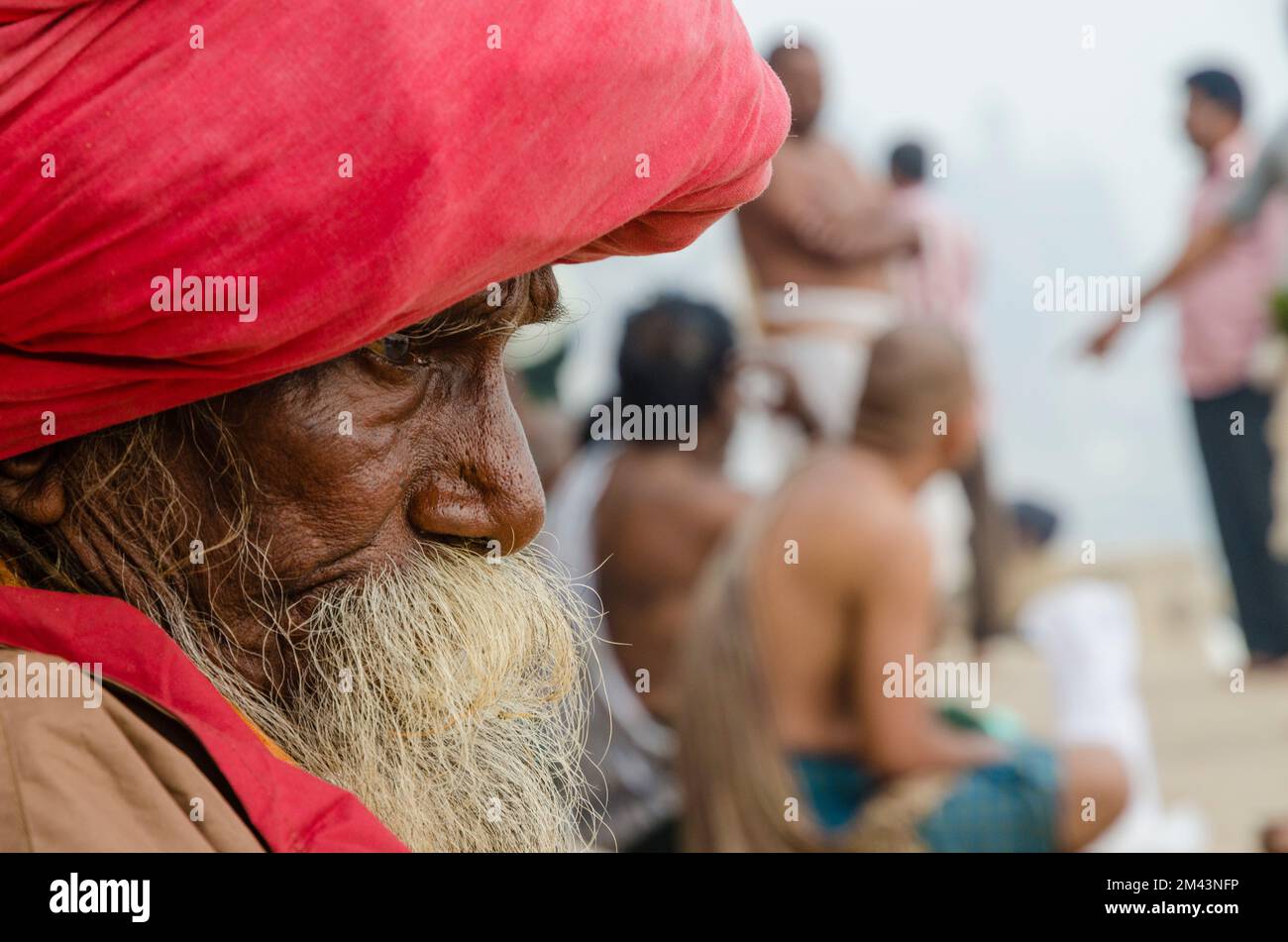 Sadhu, holy man, watching pilgrims at one of the ghats of the old city Stock Photo