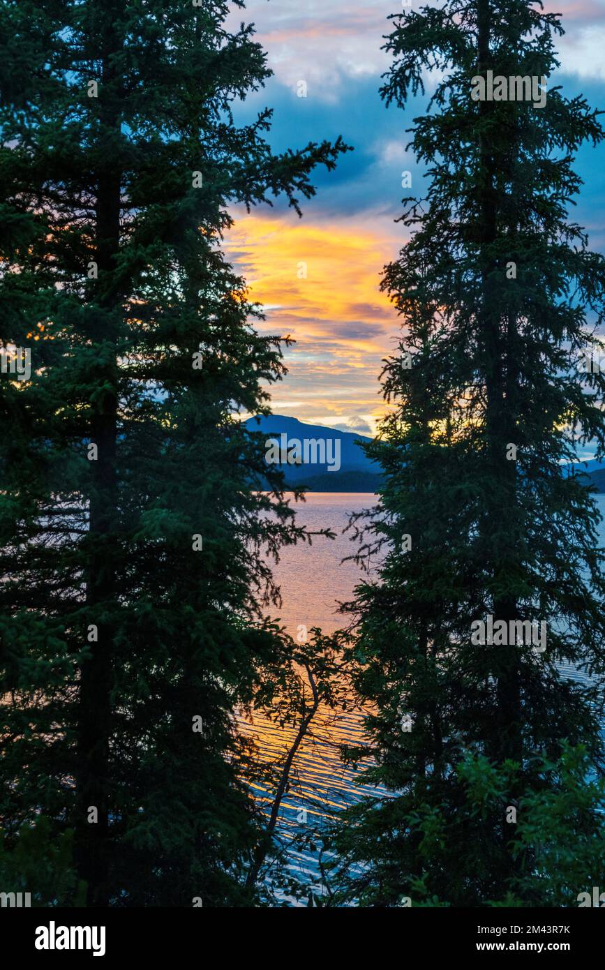 Colorful sunset reflects in Dease Lake; British Columbia; Canada Stock