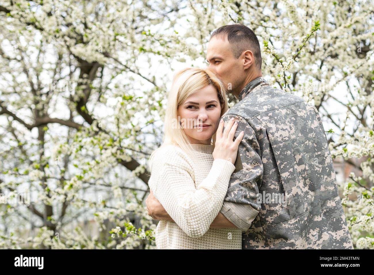 Soldier reunited with wife in park. Stock Photo