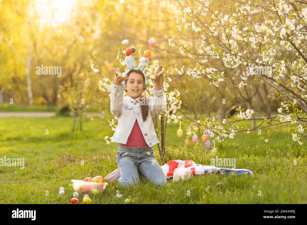 A teenage girl in a blooming garden at Easter with a US flag Stock ...