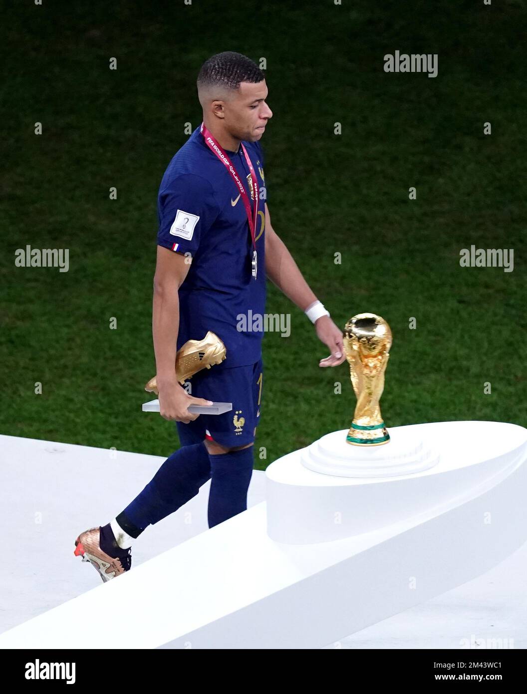 Frances Kylian Mbappe walks past The World Cup Trophy after during the FIFA World Cup final at Lusail Stadium, Qatar