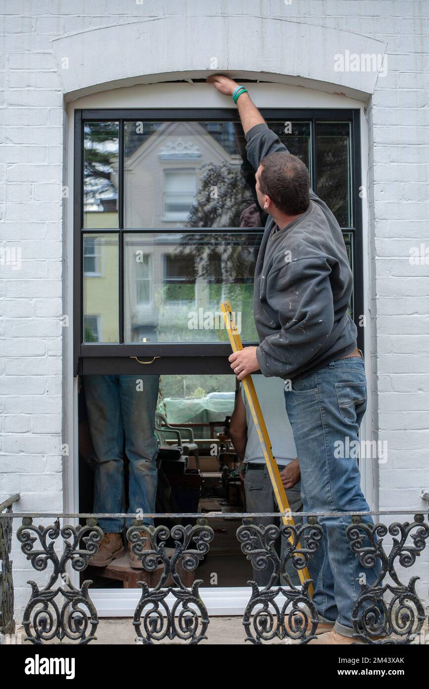 Worker is installing a sash window Stock Photo