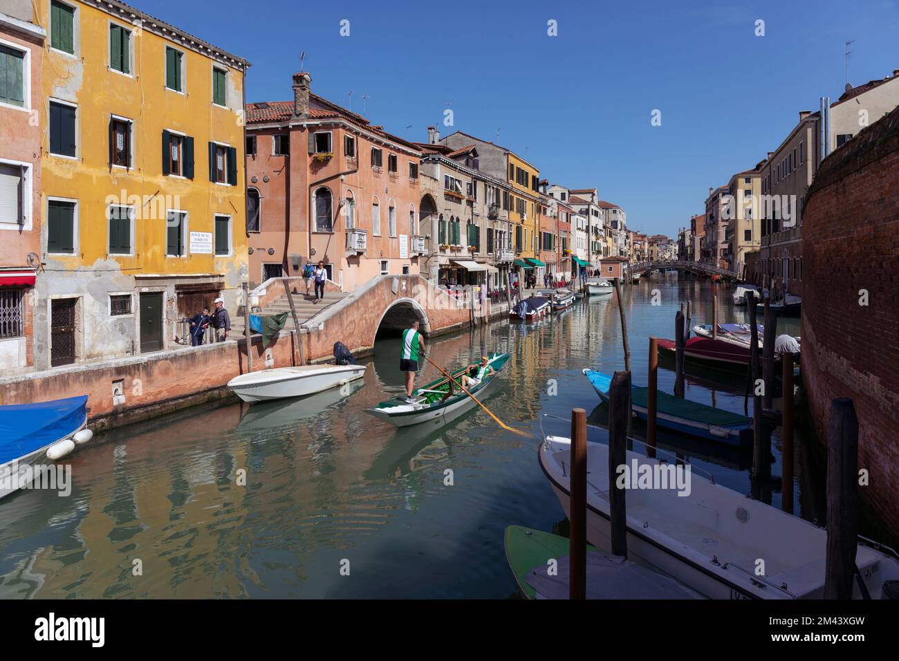 Venice, Venice Province, Veneto Region, Italy.  Boats on the Fondamenta de le Capuzine.  The man is rowing a boat known as a sandolo. Stock Photo