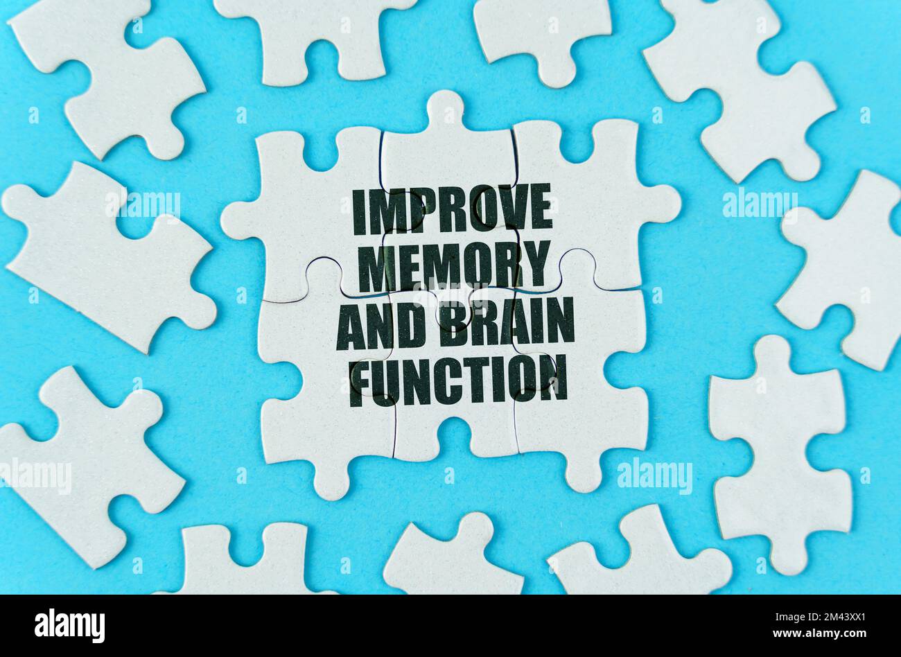 Medical concept. On a blue background are white puzzles with the inscription - Improve memory and brain function Stock Photo