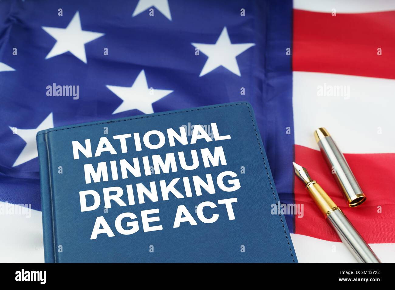 Law concept. On the US flag lies a pen and a book with the inscription - NATIONAL MINIMUM DRINKING AGE ACT Stock Photo