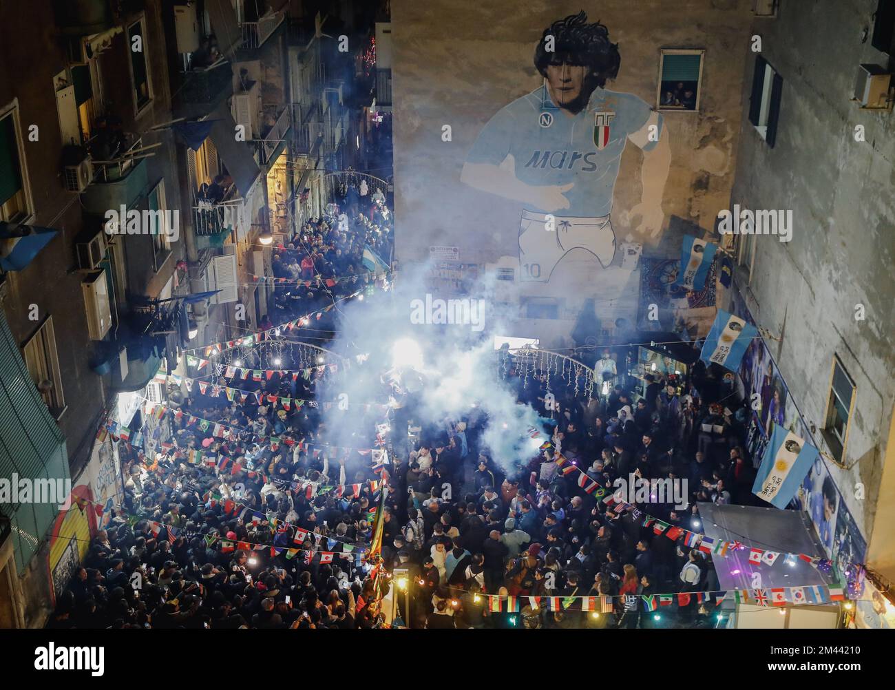 Naples, Italy. 18th Dec, 2022. Argentine fans celebrate after Argentina beat France to win the 2022 FIFA World Cup final in Qatar under the mural dedicated to Diego Armando Maradona in the Spanish quarters. Argentina won 4-2 on penalties after a 3-3 draw after extra time. Credit: Independent Photo Agency/Alamy Live News Stock Photo