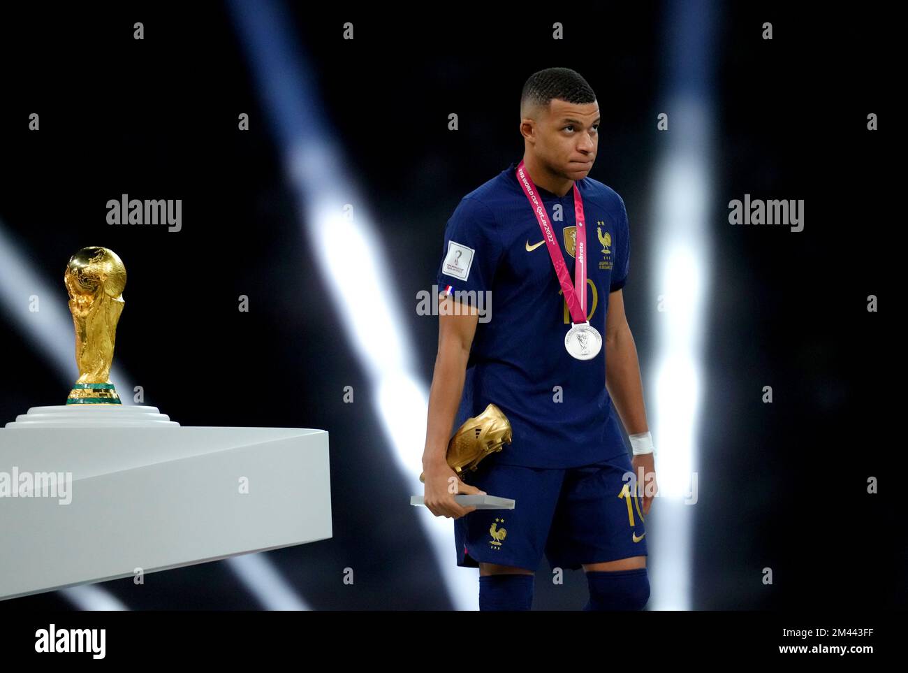 France's Kylian Mbappe walks past the FIFA World Cup trophy after being