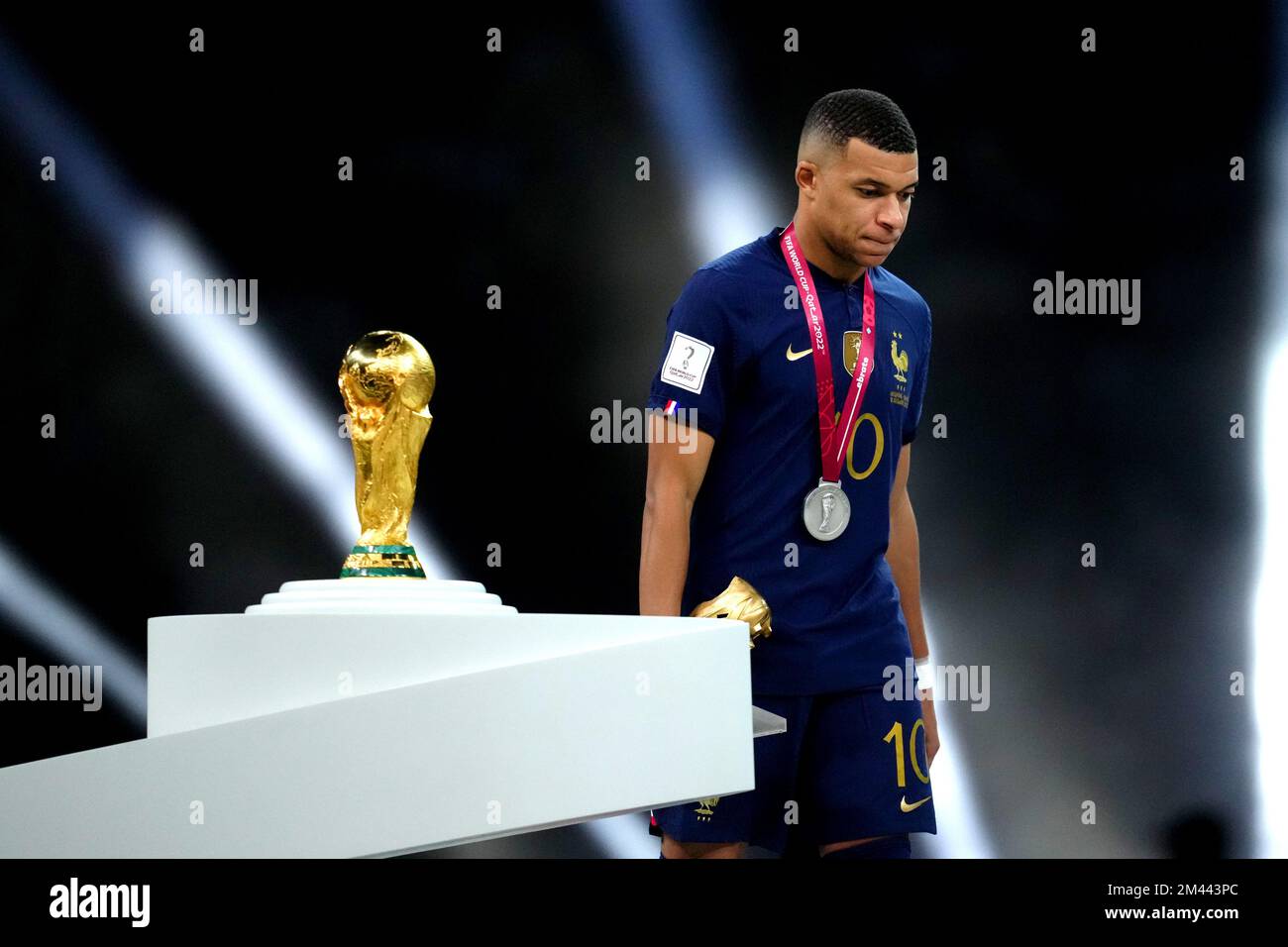 Frances Kylian Mbappe walks past the FIFA World Cup trophy after being presented with his second place medal following defeat in the FIFA World Cup final at Lusail Stadium, Qatar