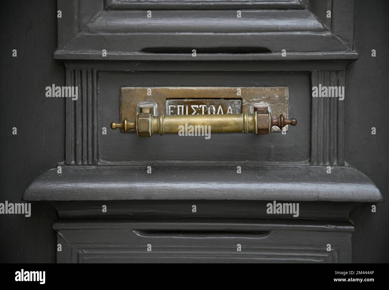 Neoclassical Lettering Old Neoclassical house grey wooden entrance door with an antique brass ...