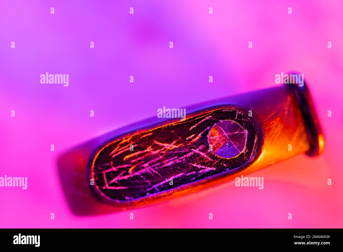 Smart watch with broken display in neon light. Fitness tracker with