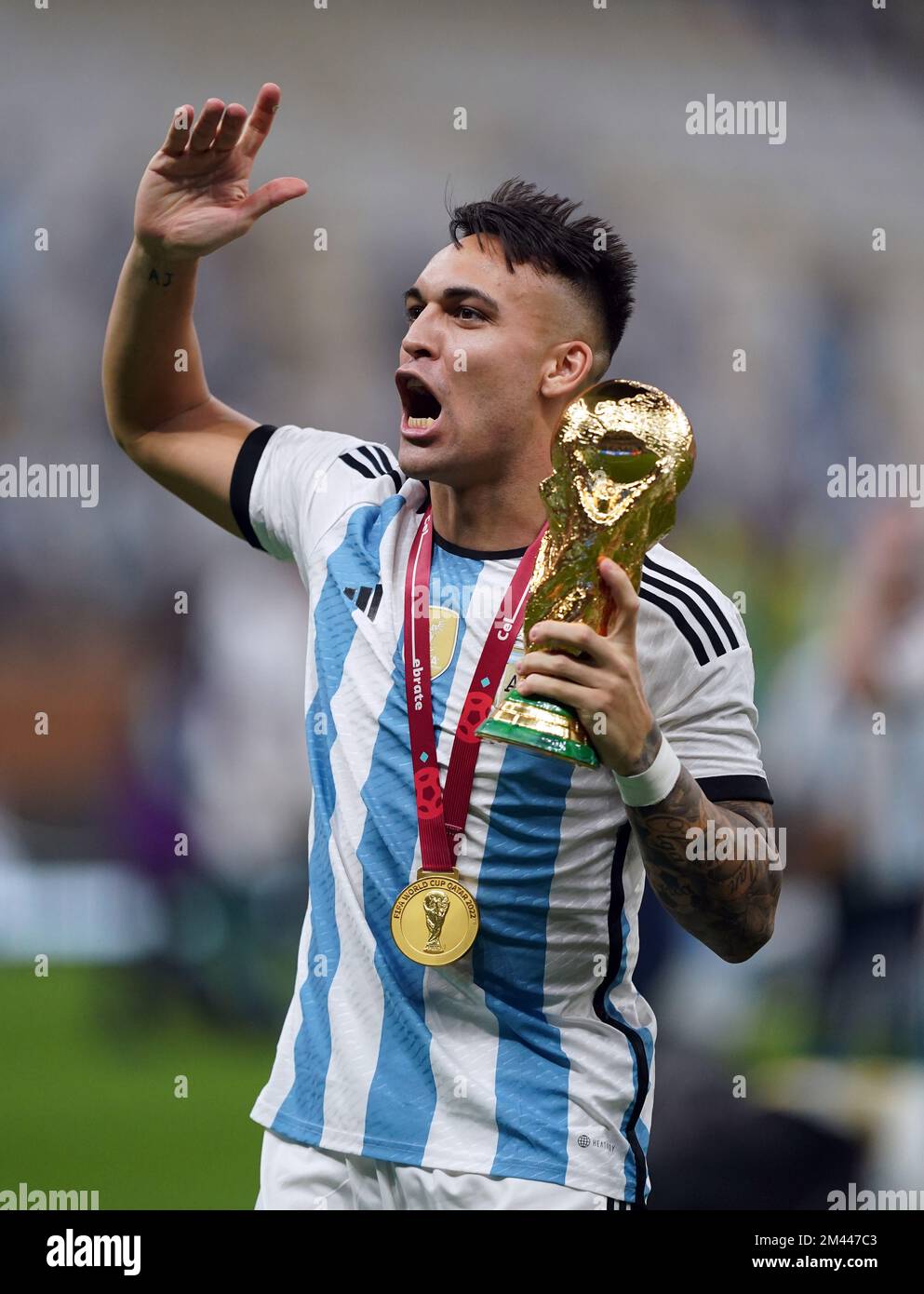 Argentinas Lautaro Martinez with the FIFA World Cup trophy following victory in the FIFA World Cup final at Lusail Stadium, Qatar