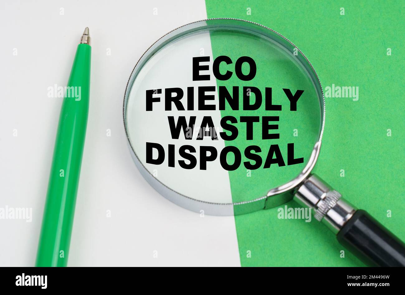 Ecological concept. On a whitegreen background lies a pen and a magnifying glass, inside which