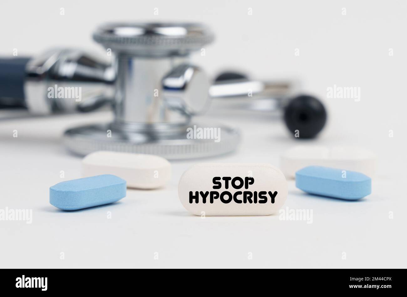 Medicine and health concept. On a white surface lie pills, a stethoscope and a tablet with the inscription - STOP HYPOCRISY Stock Photo