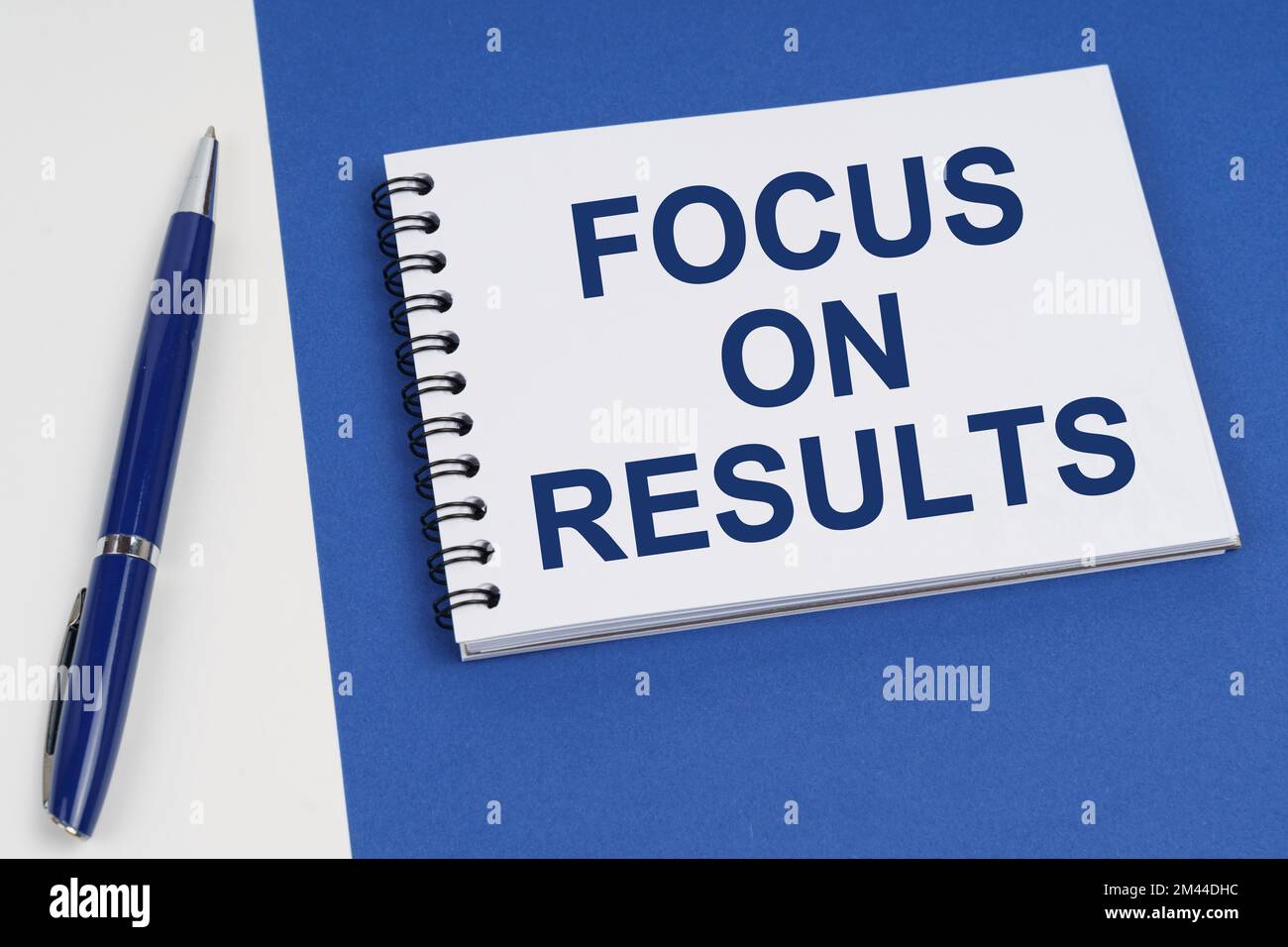 Business and finance concept. On a blue-white surface lies a pen and a notebook with the inscription - Focus On Results Stock Photo
