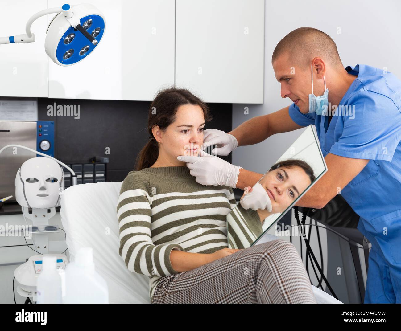 Cosmetician explaining hardware facial procedure to female client Stock ...