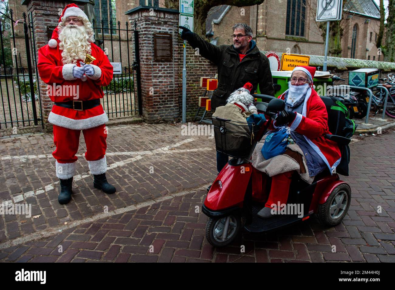 Breda, Netherlands - 18 Dec 2022, An old lady that always participates in  this run is seen talking with someone from the organization and Santa  Claus. These days many towns in countries