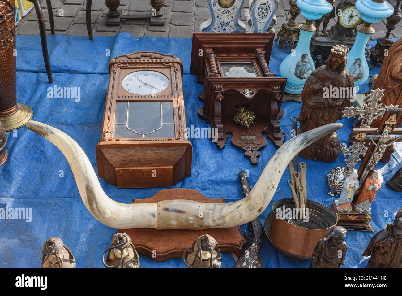 Tongeren. Limburg - Belgium 13-02-2022. Various household items of the past at a flea market sale. Wall clock, tableware, animal horn and so on Stock Photo