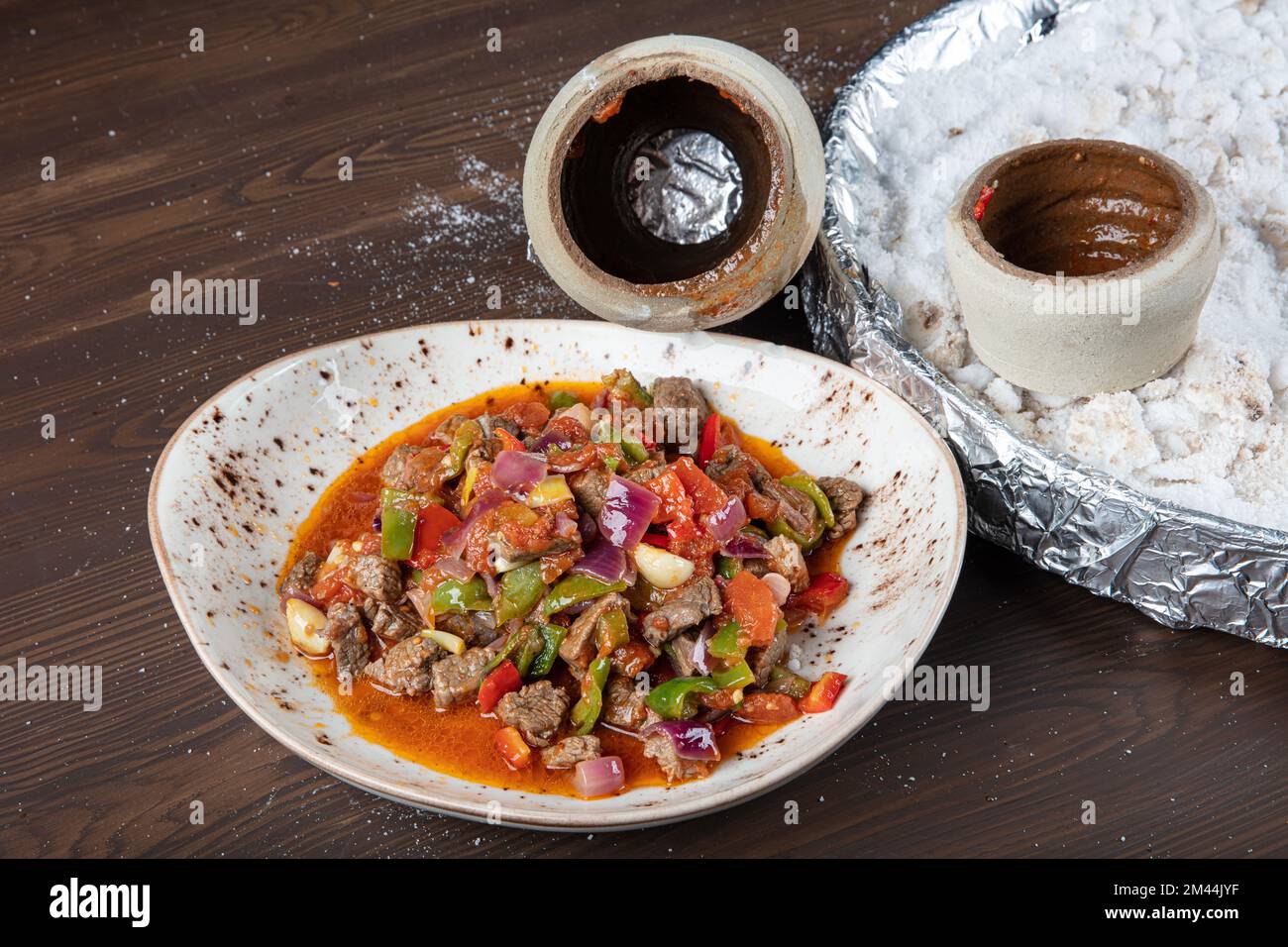 Traditional turkish cuisine. Testi kebab, local food in Turkey. Authentic Turkish Testi Kebab cooked in earthenware water jug. Stock Photo