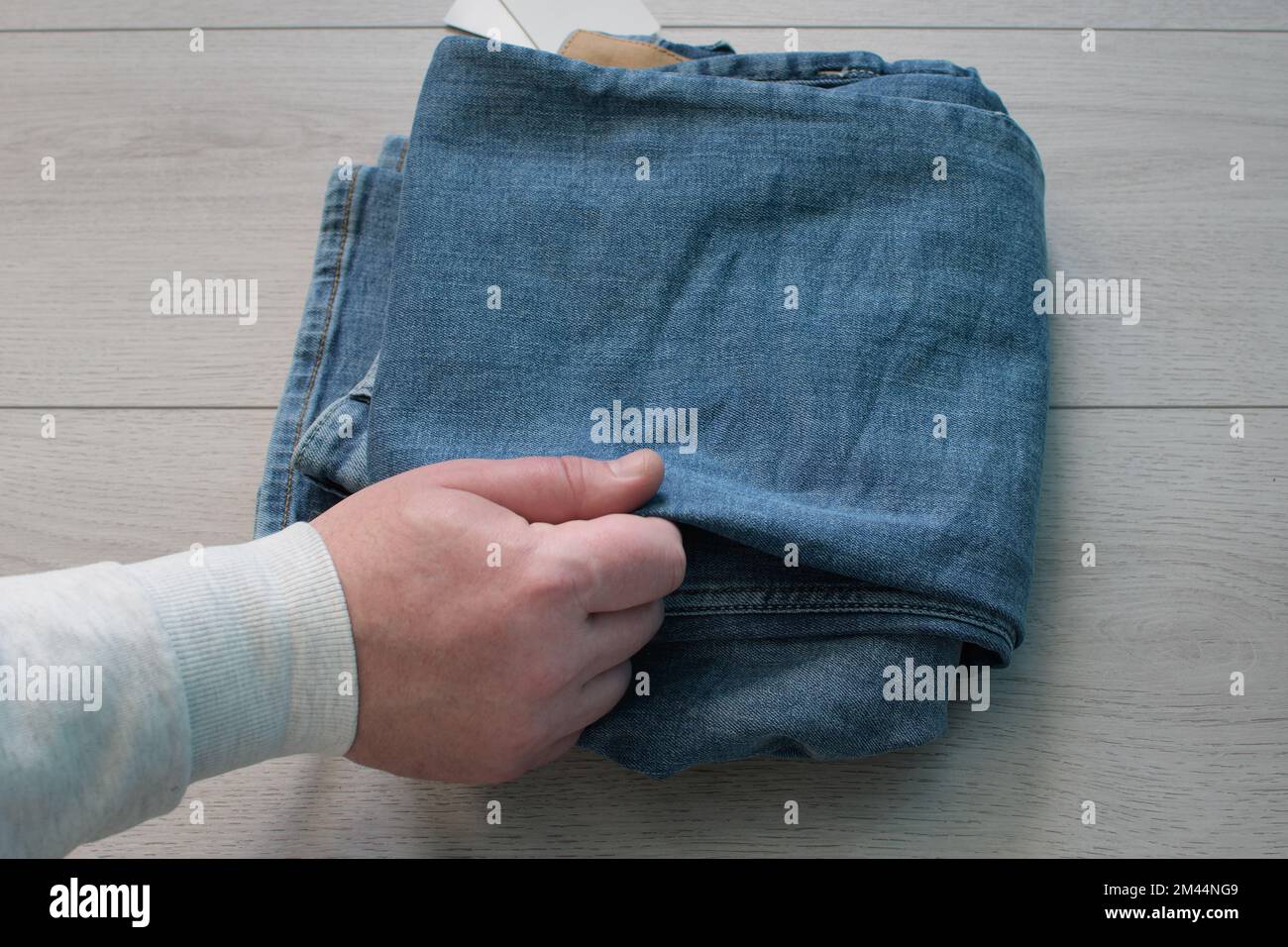 Check the stuff. The buyer checks the quality of the denim pants Stock Photo