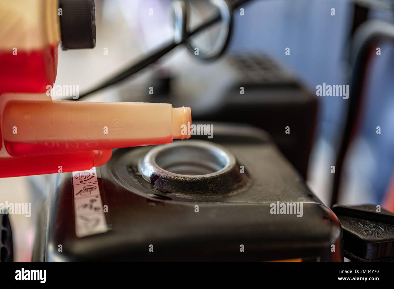 adding winter stabilizer fuel additive to a snow blower gas tank Stock