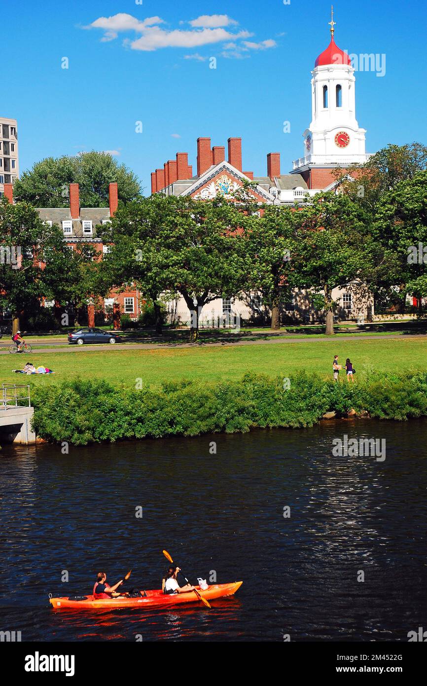 A tandem kayak glides past the Dunster House at Harvard University in