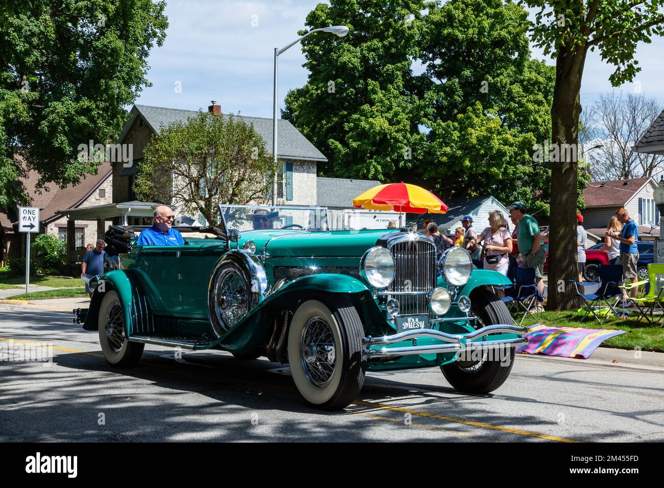 A green antique Duesenberg classic automobile cruises through Auburn