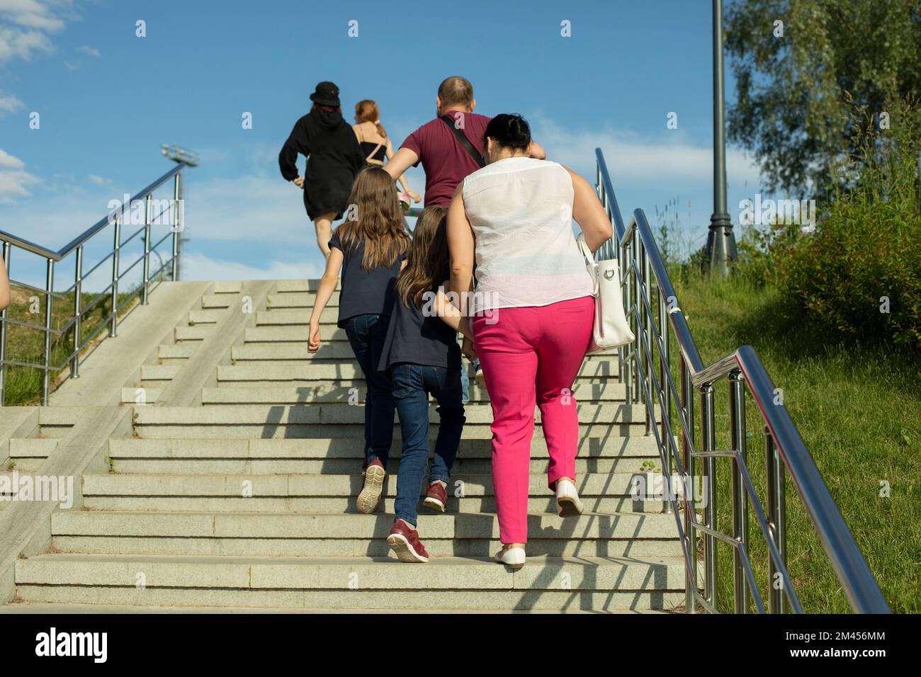 People walk up stairs in park. People climb steps in city. Stairs