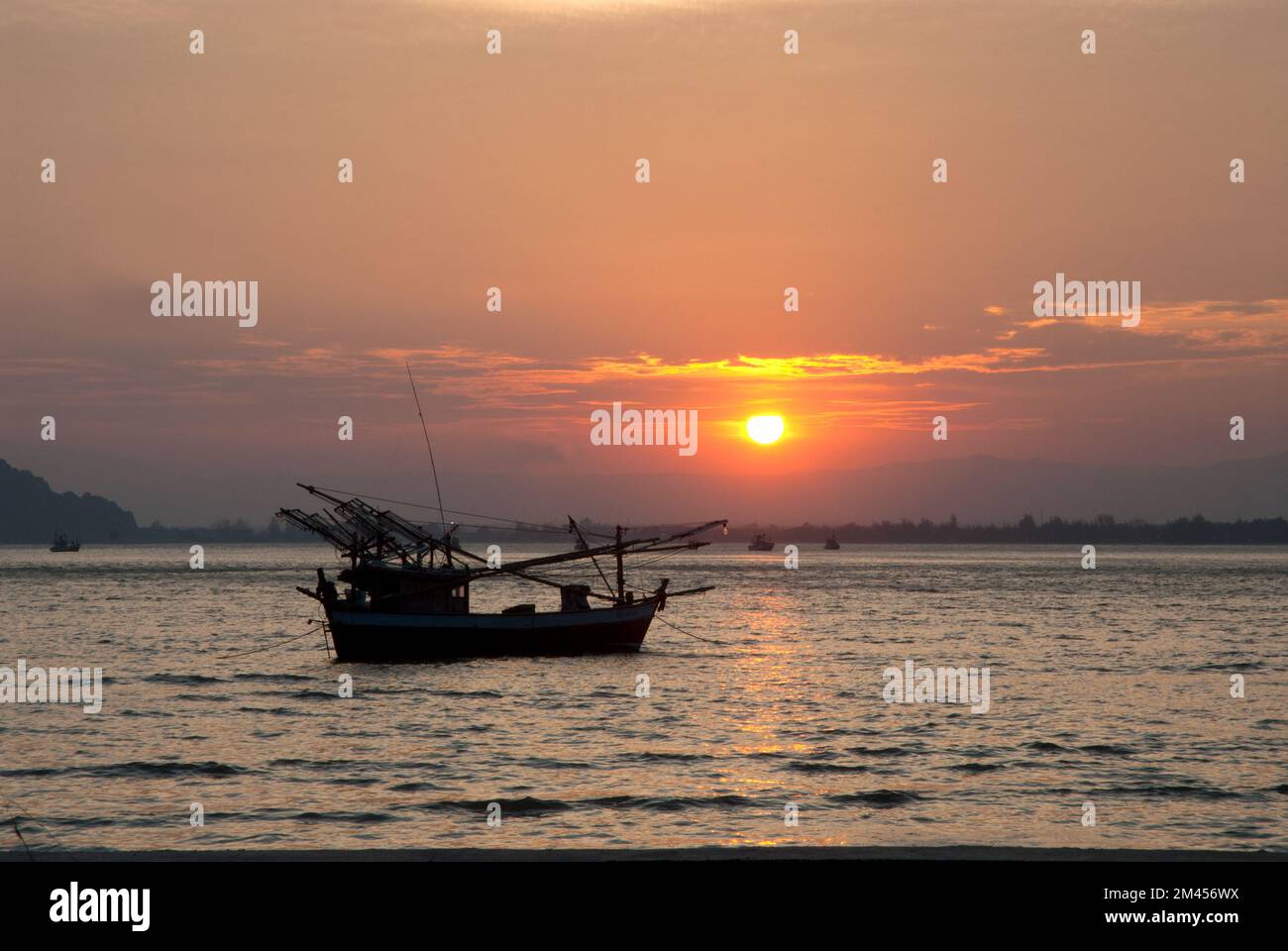 Fisherman boat at sunset on the sea in Thailand Stock Photo - Alamy