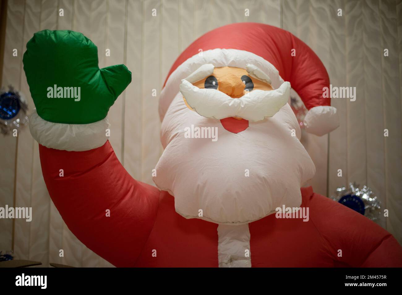 Inflatable Santa Claus. New Year game. Growth doll with air. Santa Claus waving his hand. Stock Photo