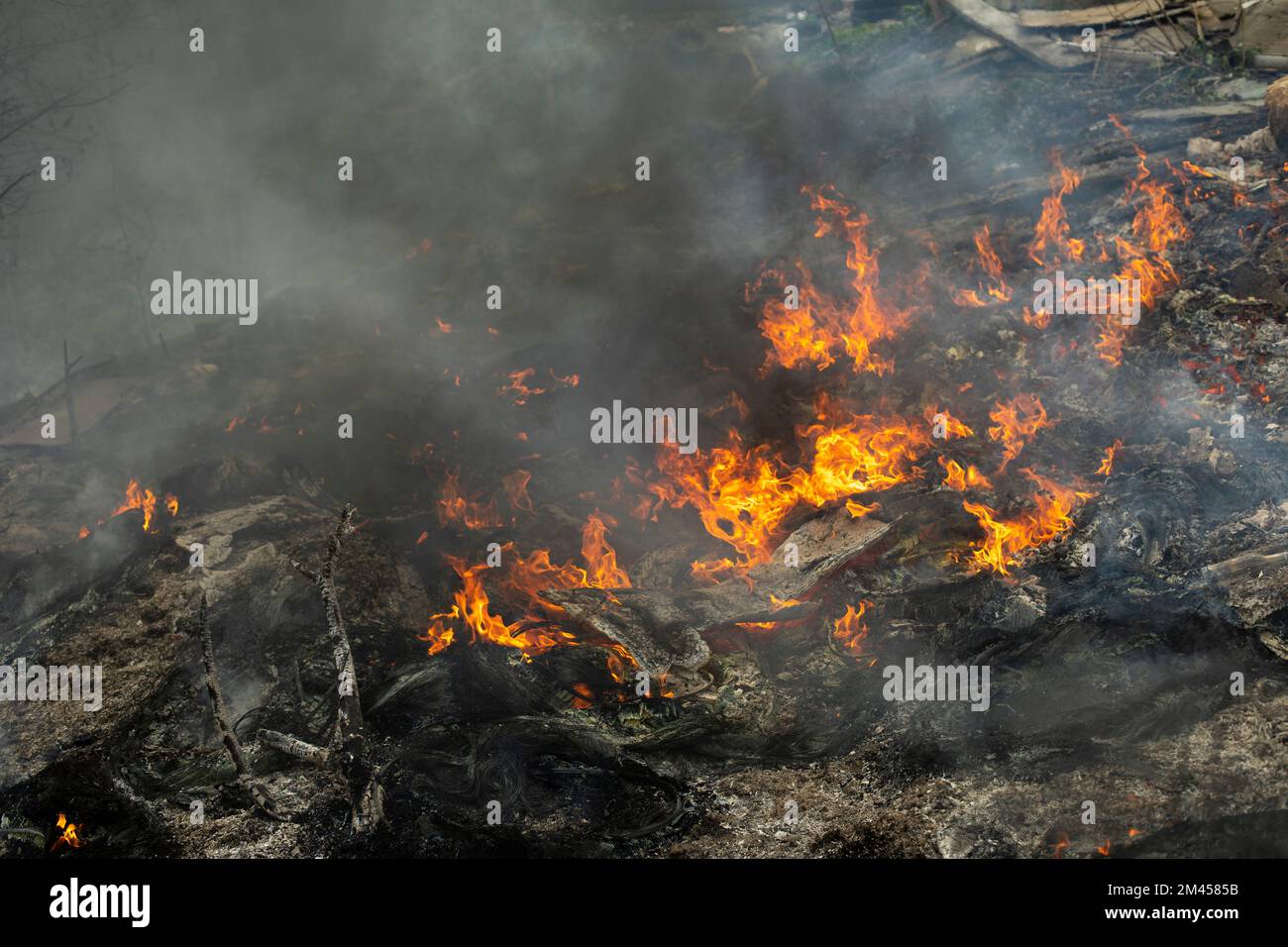 Burning of garbage. Set fire to illegal landfill. Flames and smoke. Environmental disaster Stock