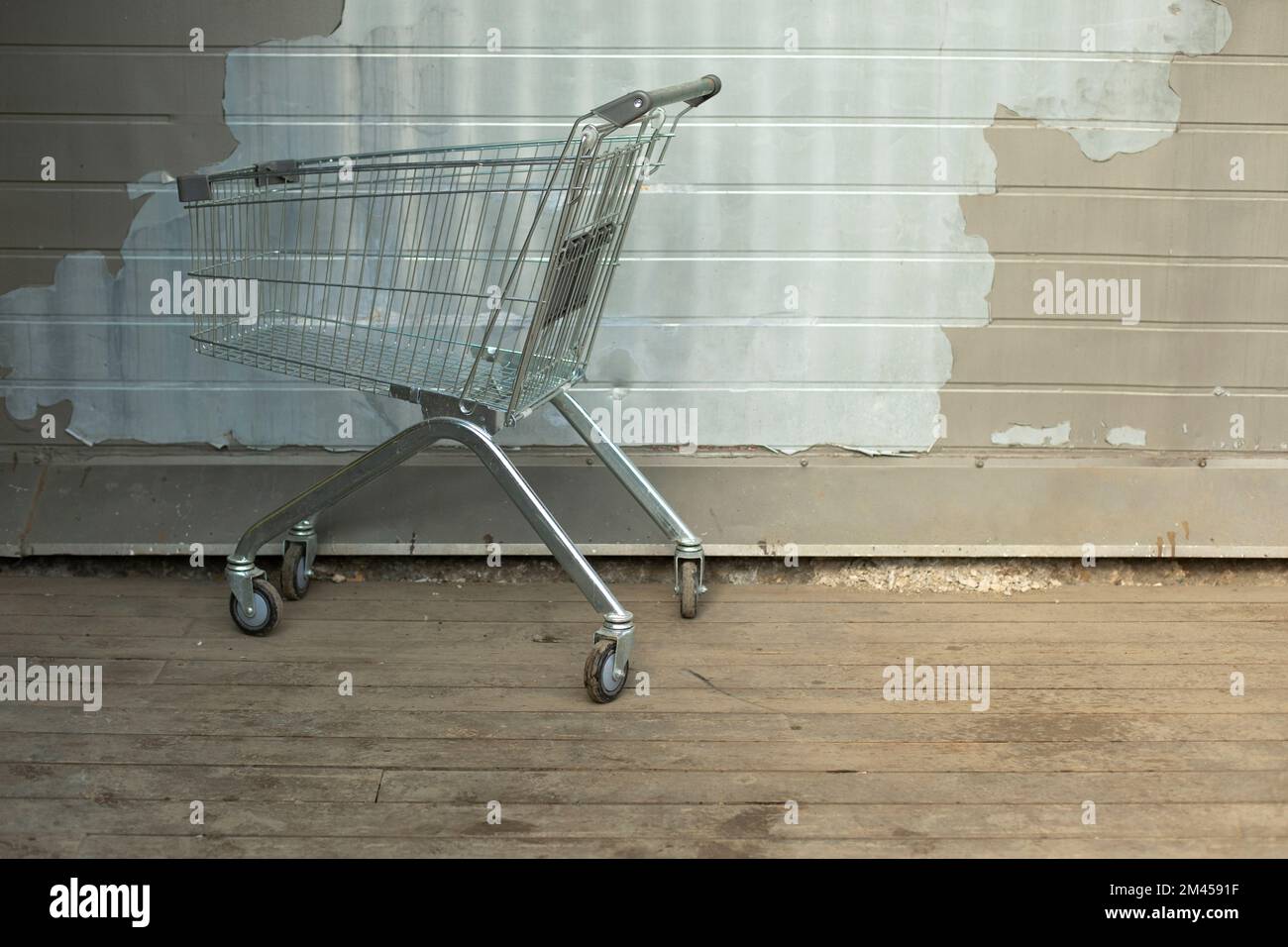 Cart for groceries from supermarket. Steel basket for goods on street. Cart on wheels. Stock Photo