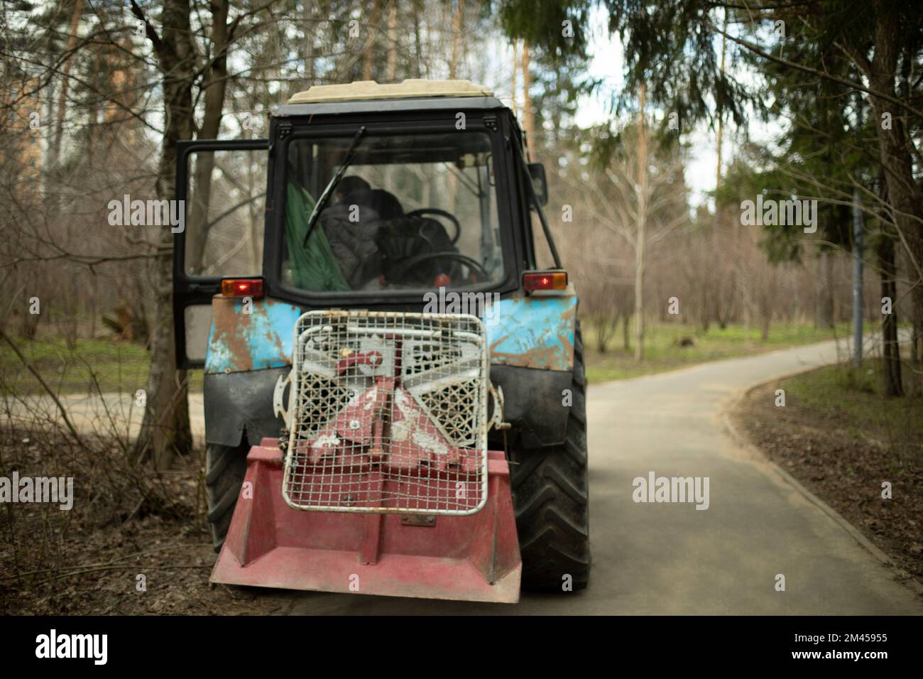 Harvesting equipment in park. Heavy technical with large wheels. Soviet tractor. Stock Photo