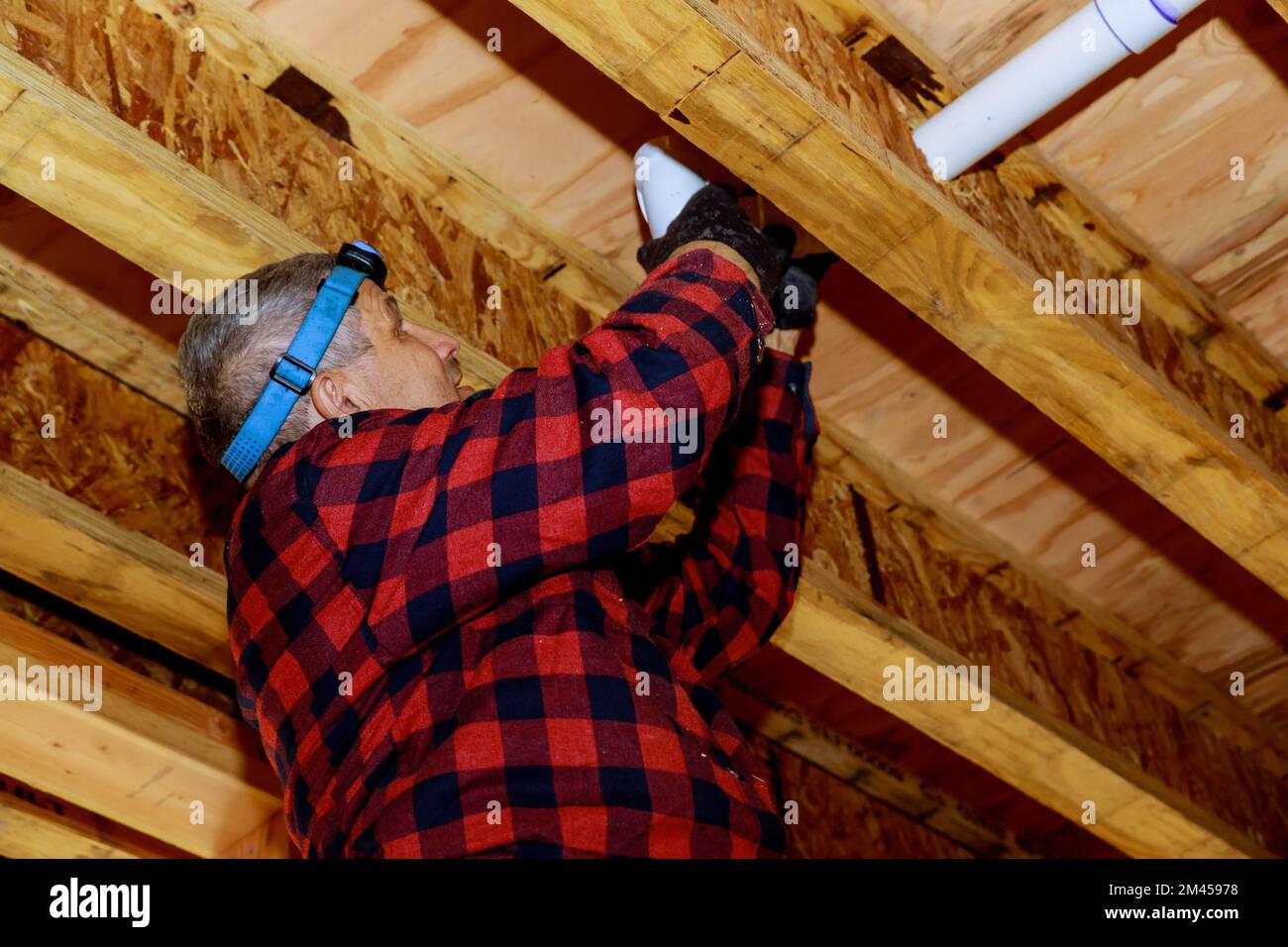 Plumber putting glue on PVC pipe, plumber joining plastic pipes using