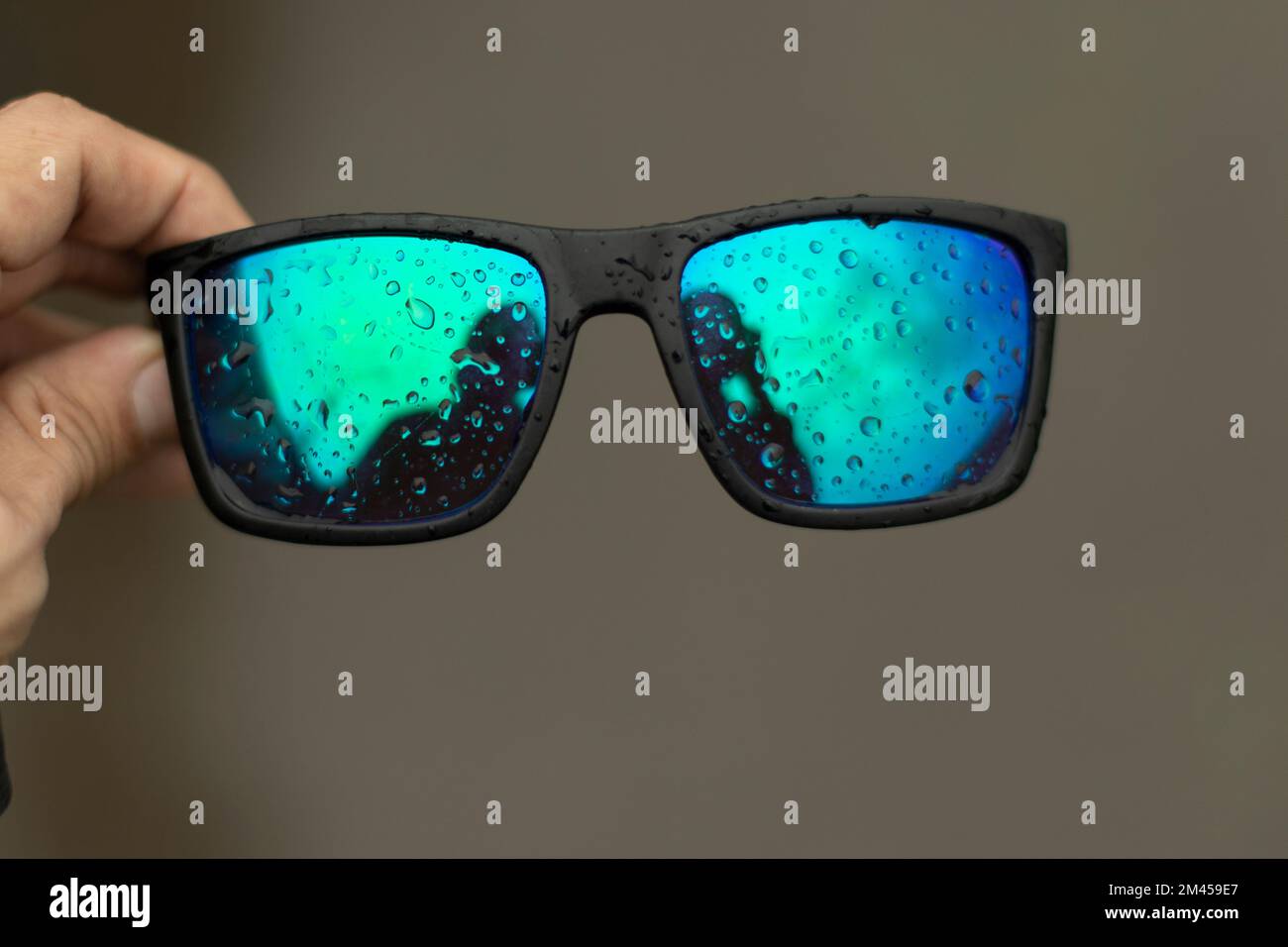 Glasses in hand. Drops on glasses. Light protective coating on glasses